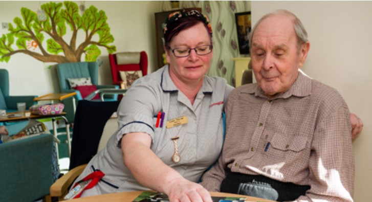 A Cornwall Care member of staff helps an elderly care home resident.
