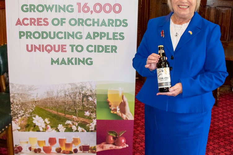 Sheryll at the NACM banner with a bottle of Cornish Orchards