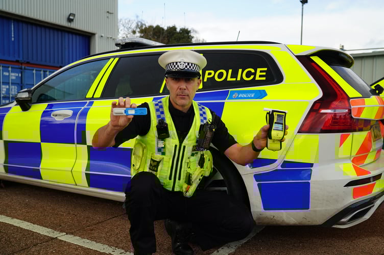 Sergeant Owen Messenger with a drug wipe and breathalyser device.