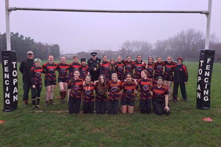 LISKEARD Looe Rugby Club Girls celebrating their successful Crowdfunder with PC Dan Lewis of Devon and Cornwall Police, who gave an additional £750 to the club after the appeal beat its target, taking the total so far to £7,490
