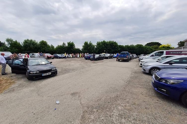 Cars belonging to the friends and family of Mike Allen await to join a long convoy accompanying him on his final journey