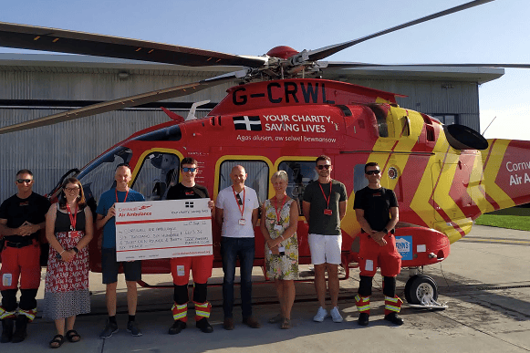 Looe 10 Miler representatives present a cheque for £6,613.36 to Cornwall Air Ambulance