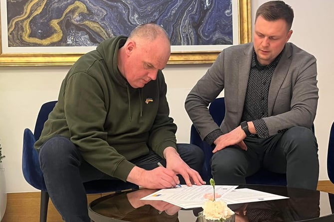 Cllr Simon Cassidy signing the twinning agreement alongside Kopychyntsi’s mayor Bogdan Kelichavyi