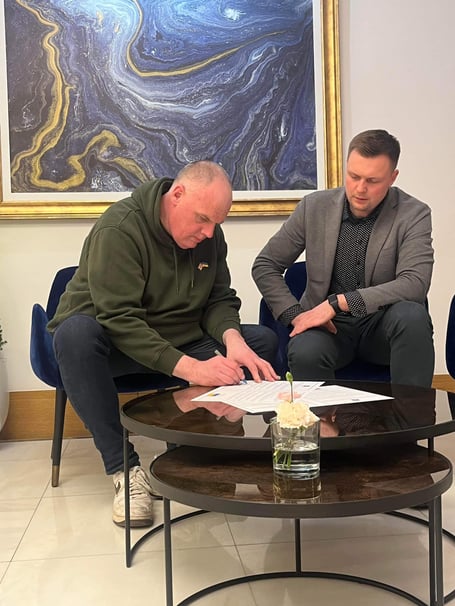 Cllr Simon Cassidy signing the twinning agreement alongside Kopychyntsi’s mayor Bogdan Kelichavyi