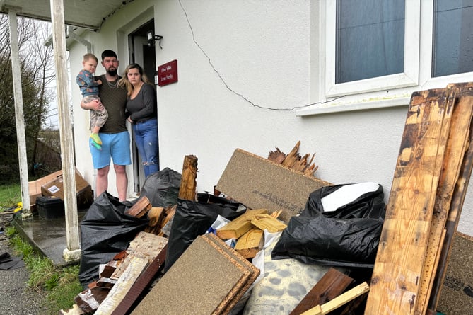 Dean and Natalie Jones with their son Logan outside their home with the rotten flooring which has been removed from their council house in Lanreath