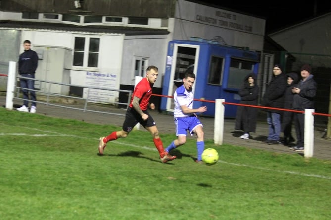 Camelford left-back Jake Chafer (right) clears the ball away from Callington Town right-back Jamie Rowlands.