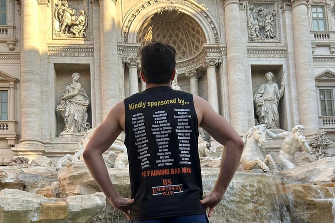 Elliot stood in front of the Trevi Fountain while displaying his sponsors names