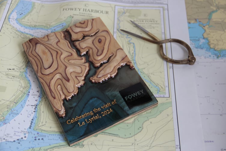 The plaque made of wood and resin which was given to the cruise ships captain