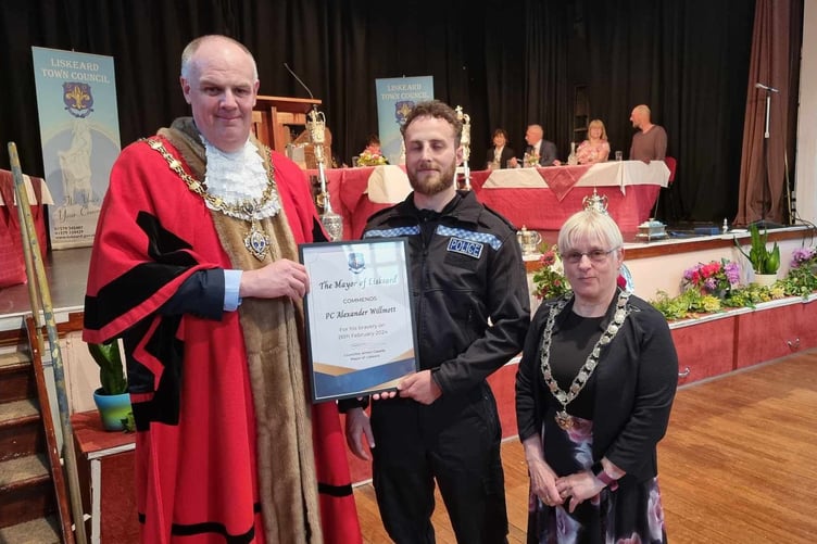 Outgoing mayor Simon Cassidy presents PC Alex Willmott with a bravery commendation. PC Willmott, who was off-duty at the time, alongside two members of the public, apprehended an offender following an armed robbery at a shop in Liskeard. Pictured right is now mayor Councillor Christina Whitty. (Picture: Terry Whitty)