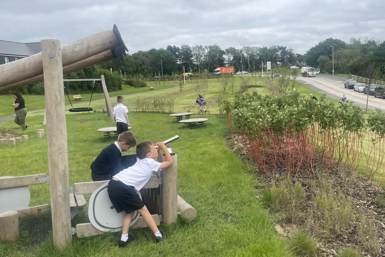 Children play with equipment at the new play park at Treledan