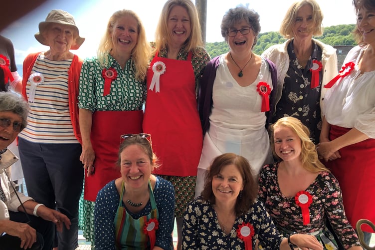 The tram behind the cream tea fundraiser, all wearing red rosettes in Margaret's memory