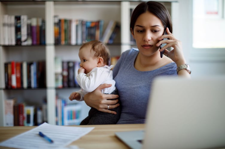 Worried mother using mobile phone an laptop at home
