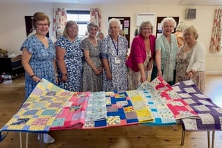 Members of Wilcove WI present quilts to representatives from Project Linus
