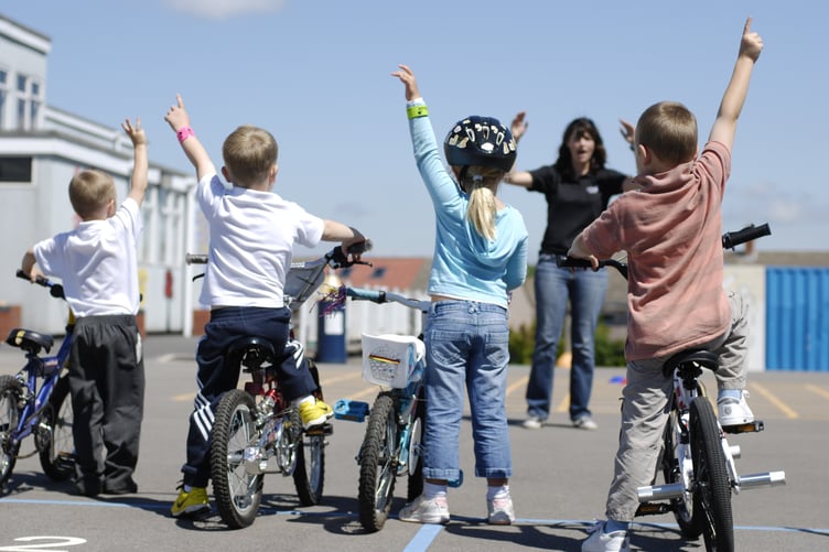 A Sustrans Bike It officer leads a cycle skills session in a school playground.