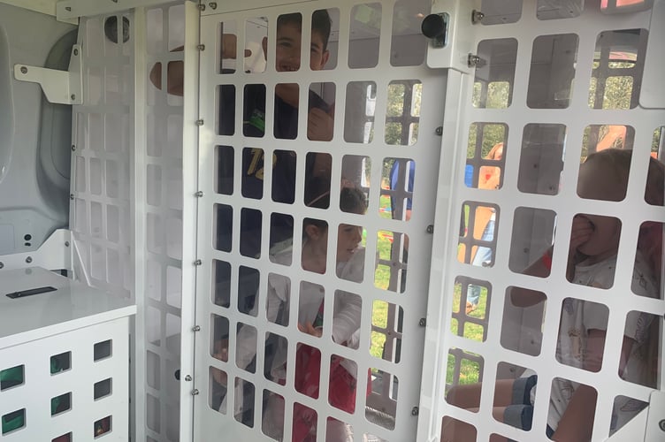 It's a thumbs up from these children who were rewarded with stickers for their time 'locked up' in the police van. (Photo credit: Sarah Martin)