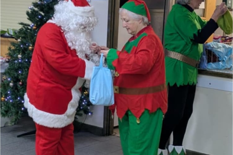 Two Elves and Santa arrived to give out handmade gifts to all Pensilva Women's Institute members and chocolates to the visitors