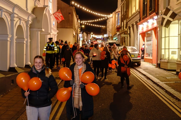 Orange balloons symbolising a brighter future, free from violence against women and girls, the group of more than 40 head past Saltash Guildhall along Lower Fore Street. (Picture: Mike Pitches Photography)