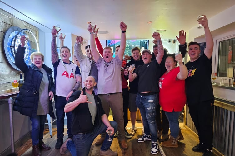 FUNDRAISERS celebrate at JJs Bar in Liskeard after their darts marathon for Macmillan Cancer Support