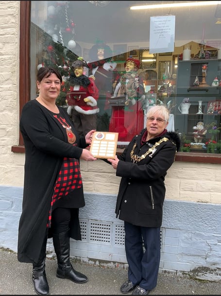 Town Mayor Christina Whitty presents Sarah Stewart, owner of Trinkets and Treasures, with the trophy for Best Dressed Christmas Window in Liskeard. 