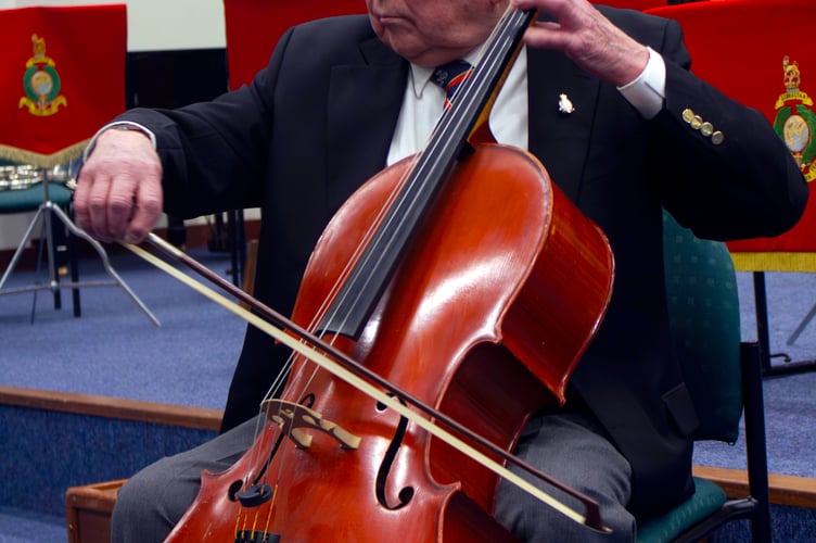 George Latham shows Royal Marines musicians his cello skills