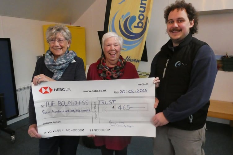Marilyn King and Dot Dunning from the Looe Community Players hand over a cheque for £465 to Caleb Barron from the Boundless Trust charity in Looe