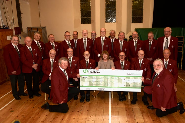 The Rame Peninsula Male Voice Choir together with Sarah Rigg of Torpoint Trussell Trust after receiving the cheque. Pictured kneeling left is David Turner (Treasurer)﻿ and right is Ian Keir. Choir chairman Jon Kidd is pictured standing behind Sarah Riggs. (Picture: Sue Webb)