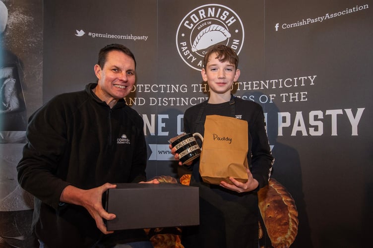 Cornish Pasty Association chairman Jason Jobling presents junior winner Paddy Gamble with his prize at the World's Fastest Crimper contest in Truro 