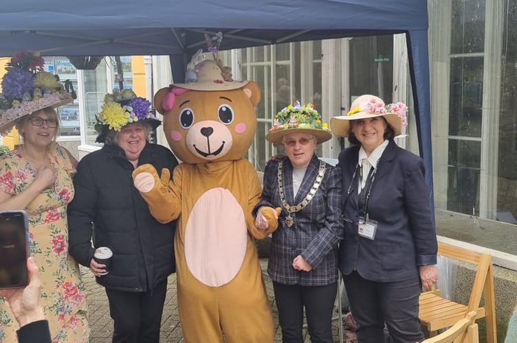 Participants in their Easter bonnets next to Treasure the teddy 