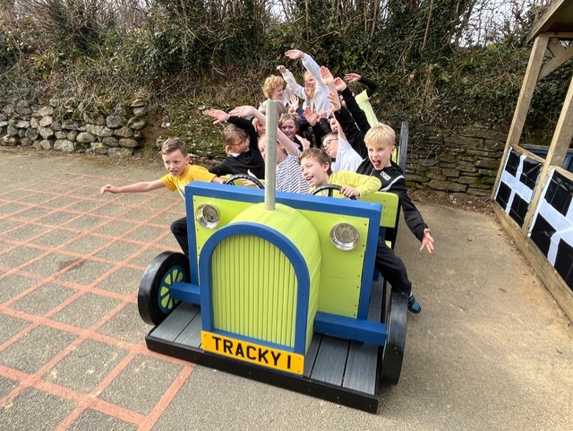 Youngsters at Trenode Primary School test out their new playground tractor provided by the Looe Shedders