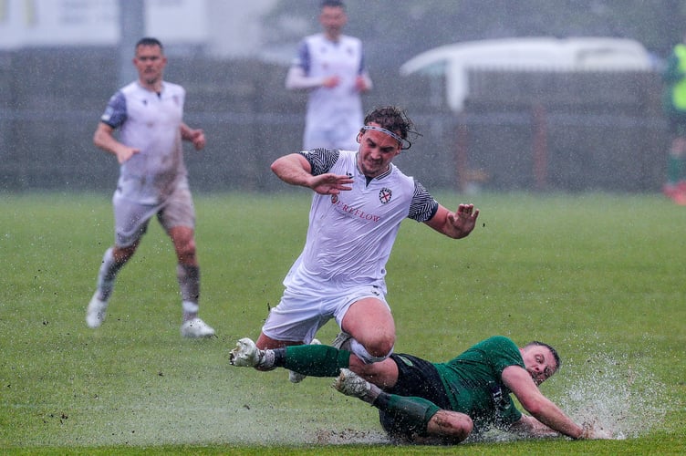St Blazey's Jacob Rowe puts in a slide tackle on St Austell's Callum Watson 