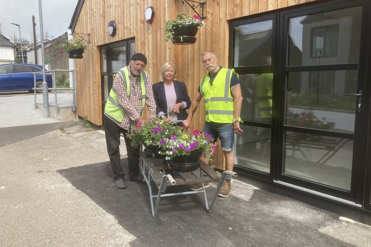 Pictured hard at work for Liskeard in Bloom are John Crumpton, Jane Pascoe and John Hesketh hanging the new floral baskets at the newly refurbished work units in the Cattle Market 