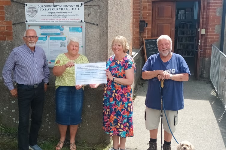 Chair Maura Swabey and Nigel Jones of Downderry and Seaton Residents Association (DaSRA) handing over a cheque for £10,000 to chair Sue Slyfield and treasurer Keith Smith of the Downderry and Seaton Village Hall