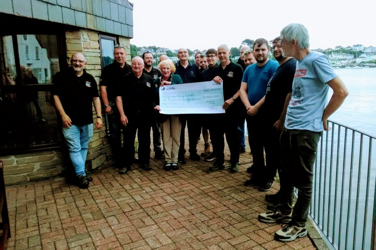 Sue Hooper receiving a cheque from Saltash Model Club chairman David Parsons and members of the club at Ashtorre Rock