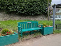 New bench and planters at bus stop outside railway station