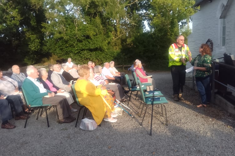 The congregation at Bealbury Chapel, Saltash, watch on as Ian butler receives a cheque on behalf of the Blood Bikes from money raised at the recent annual rally