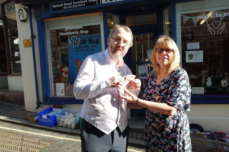 Geoff Lewis, a volunteer at the Food Hub Liskeard CIC, receives £50 from Tracy Adams, chair of the Liskeard Traders Association 