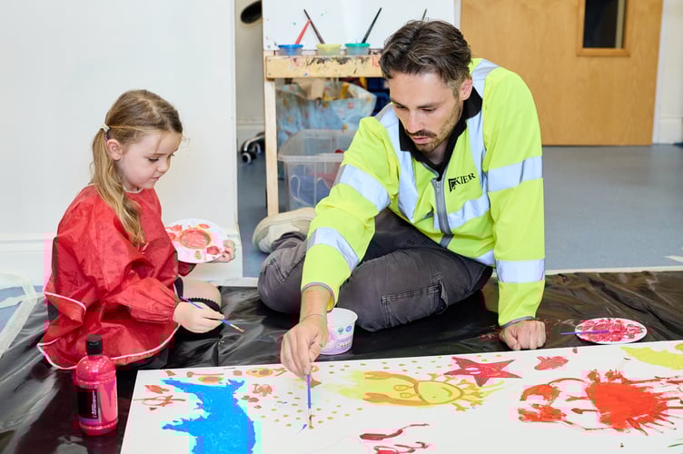 EA and Kier staff painting hoardings with students at Mousehole Primary School.