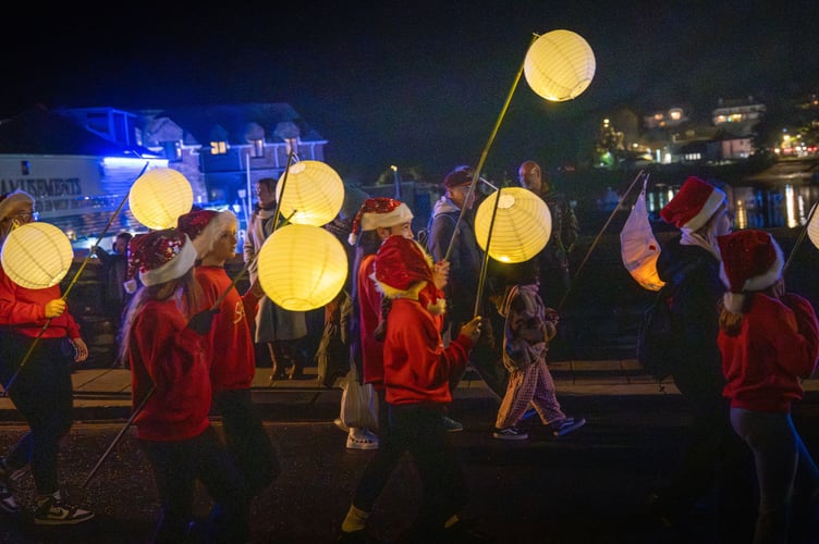 Youngsters make their way across the bridge and into the bustling streets of Looe as part of the annual Lantern Parade