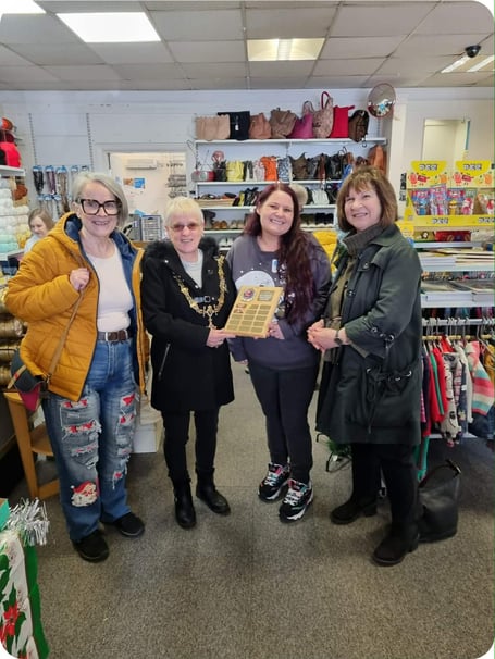 Liskeard Mayor Christina Whitty presents the Best Christmas Window award to Cassandra from Sue Ryder shop alongside fellow councillors Sylvia Berry and Lori Reid
