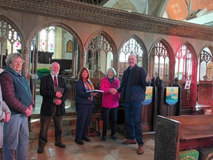 Church recording volunteers present Reverend with special book 