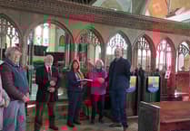 Church recording volunteers present reverend with special book