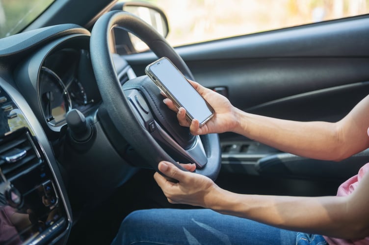 Mockup image of a woman holding and using mobile phone with blank screen while driver a car, for GPS, Lifestyles photo in car, Interior, front view. With woman hand holding phone.