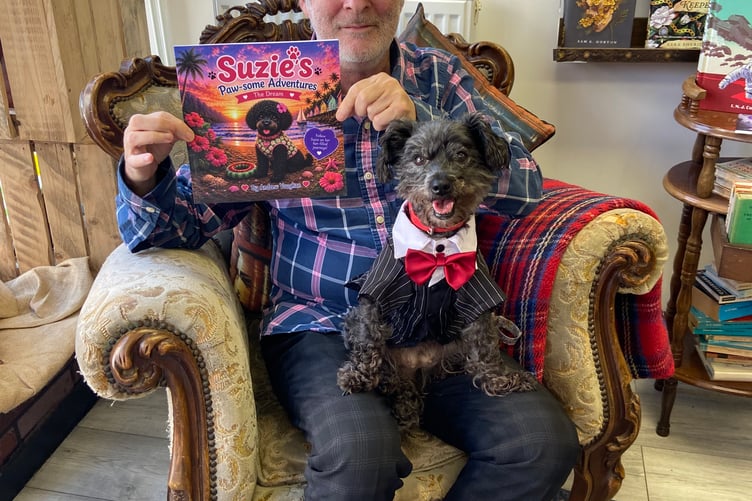 'Smile for the camera' — nine-year-old Suzie poses with author Andrew Vaughan and his new book inspired by her. She even wore her 'business suit' for the occasion