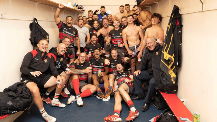 Camborne's players and coaching staff celebrate their nine-try success at Cambridge last weekend.