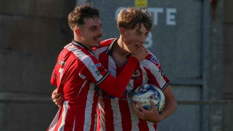 Saltash United goalscorer Deacon Thomson is congratulated by Kieran O'Melia.