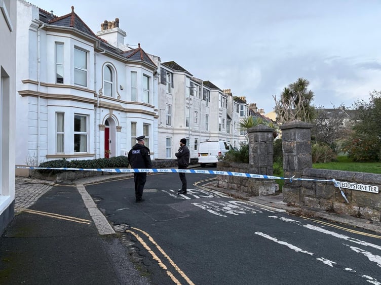 Police stand guard after they launched a murder investigation after a man was found seriously injured in a service lane at West Hoe in Plymouth